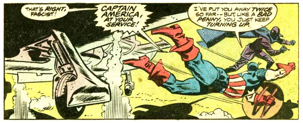 A panel from this issue showing Captain America jumping out of a plan to attack a man in a dark suit and mask with a dark blue cape. Captain America says “That’s right, fascist! Captain America at your service! I’ve put you away twice so far — but, like a bad penny, you just keep turning up.” A panel from this issue showing Captain America jumping out of a plan to attack a man in a dark suit and mask with a dark blue cape. Captain America says “That’s right, fascist! Captain America at your service! I’ve put you away twice so far — but, like a bad penny, you just keep turning up.”